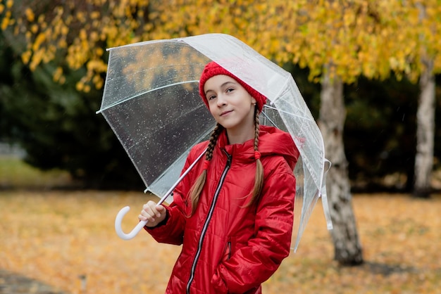 Een mooi jong meisje loopt in de regen met een transparante paraplu Autumn Atmosphere Weather