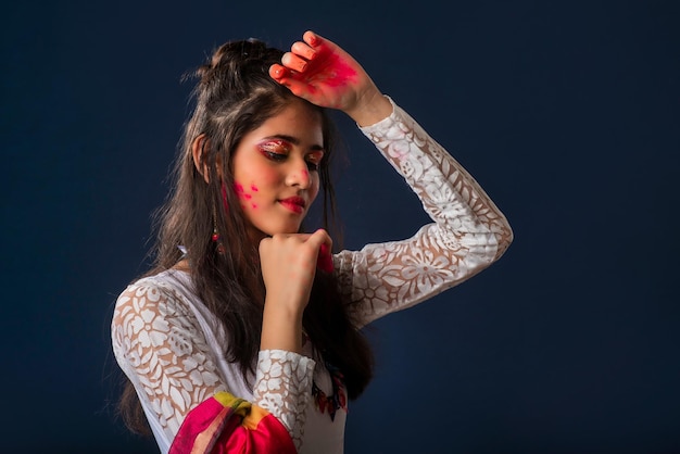 Een mooi jong meisje speelt met kleuren ter gelegenheid van Holi Het concept voor het Indiase festival Holi