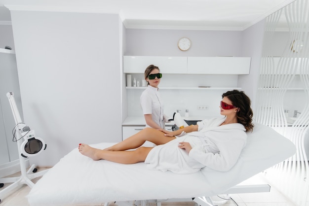 Een mooi jong meisje zal laser ontharing ondergaan met moderne apparatuur in een spa salon. Schoonheidssalon. Lichaamsverzorging.