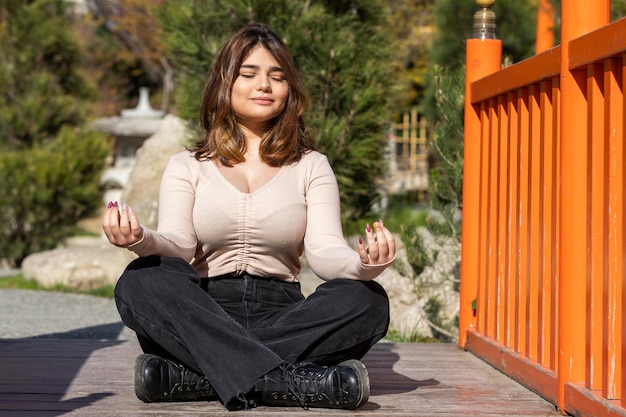 Een mooi meisje dat op de grond zit en aan het mediteren is Foto van hoge kwaliteit