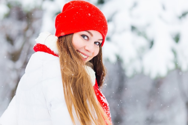 Een mooi meisje in winterkleren kijkt glimlachen