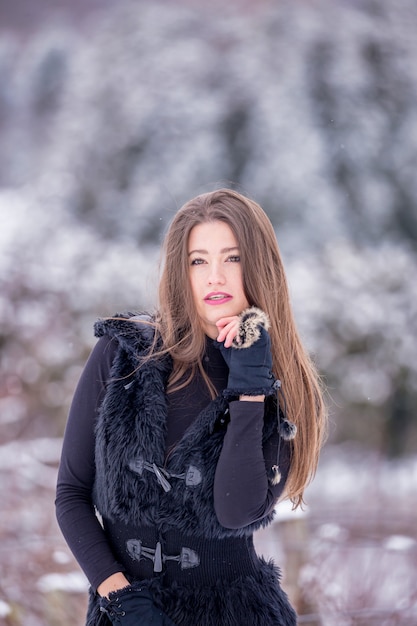 Een mooi meisje in zwarte kleding in de winter