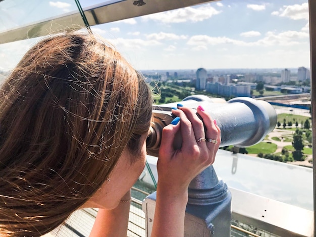 Een mooi meisje kijkt naar het landschap een panorama van de stad in de observatiekamer een paar