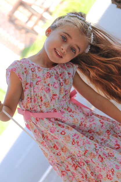 een mooi meisje met bruin haar en lichtgroene ogen, blij en lachend met een rode ballon in Alicante