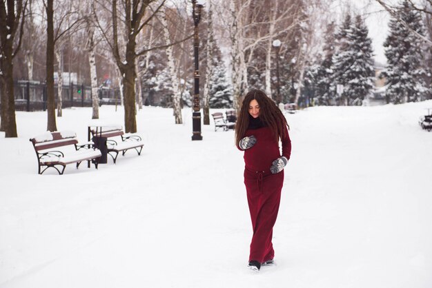 Een mooi openlucht zwanger vrouwenportret in sneeuwpark