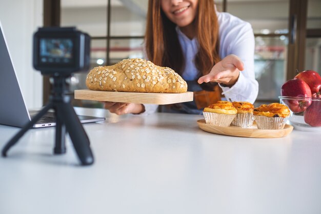 Een mooie aziatische foodblogger of vlogger die een video op camera opneemt