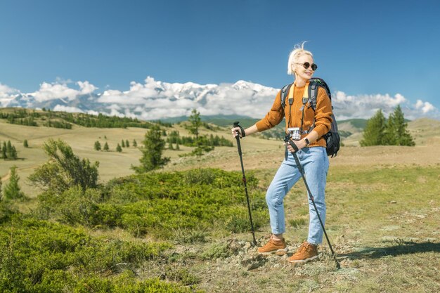 Een mooie blanke vrouw met rugzak en geniet van een zonnige zomerdag in de bergen travel lifestyle concept avontuur zomervakanties outdoor wildlife