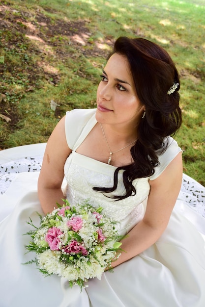 Een mooie bruid met een boeket bloemen op het veld.