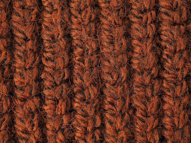 Een mooie close-up van een met de hand gebreid warm en zacht wolpatroon Textuur van een bruine trui sokken of sjaal oranje gebreide materiële achtergrond