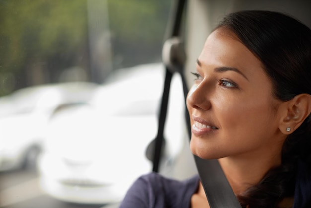 Een mooie dag om onderweg te zijn Een mooie vrouw kijkt uit haar raam terwijl ze in een auto rijdt