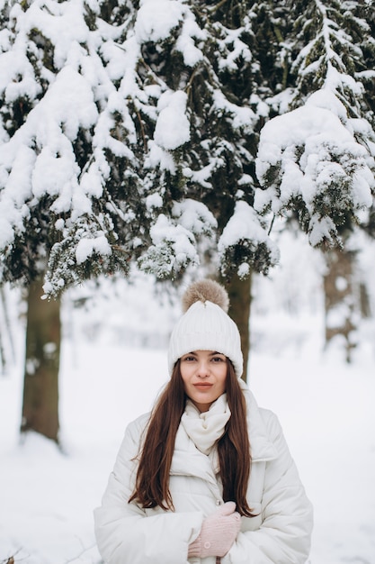 Een mooie en mode vrouw in witte warme kleding lopen in besneeuwde weer.