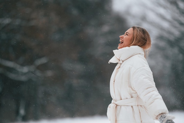 Een mooie gelukkige vrouw geniet van een wandeling buiten in de winter.