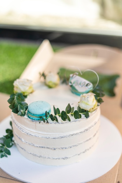 Een mooie heerlijke zoete taart wit hoog en macarons en minimalistisch decor van bovenaf. Hoge kwaliteit foto