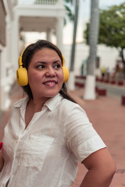 Foto een mooie jonge latina die op straat naar muziek luistert