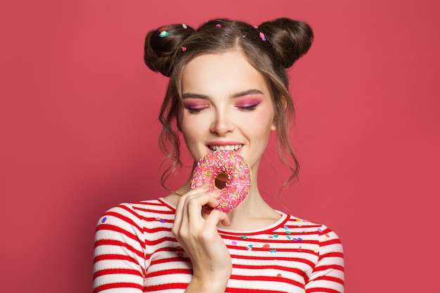 Foto een mooie jonge vrouw die donuts eet.