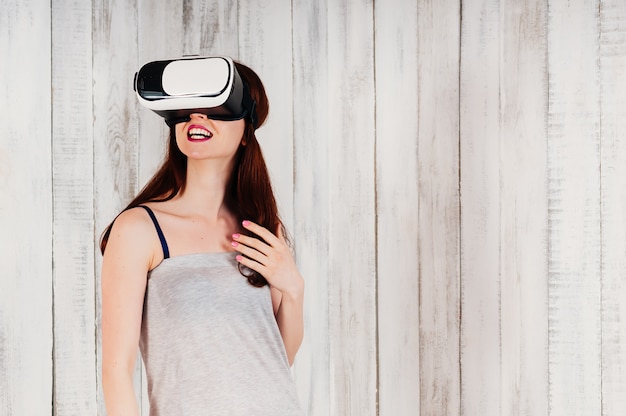 Een mooie jonge vrouw, gekleed in virtual reality-bril, opgewonden glimlachend