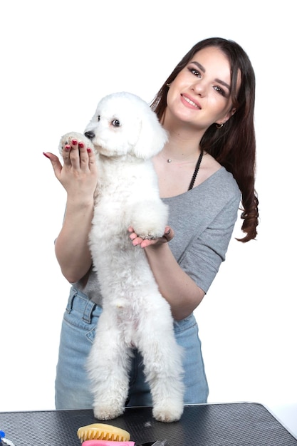 Een mooie jonge vrouw houdt haar bichon-puppy vast