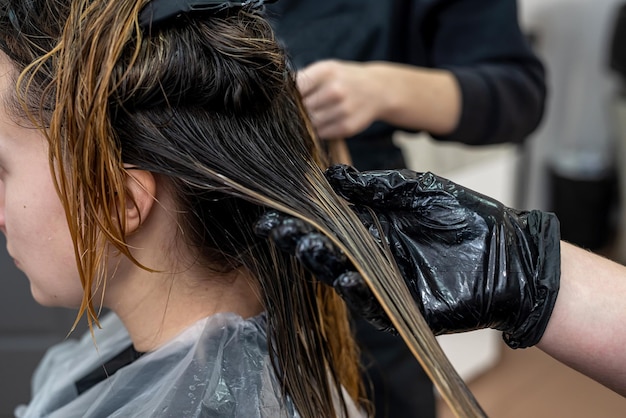 Een mooie jonge vrouw met een schoon, perfect gezicht wordt haarverf gepompt om haarkleurconcept te verven