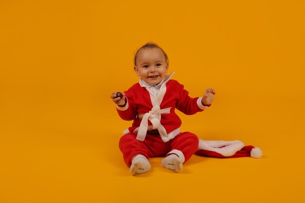 een mooie kleine jongen in een kerstmankostuum en een kerstmuts voor het nieuwe jaar