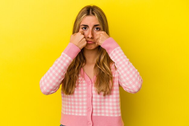 Een mooie vrouw die zich voordeed op gele achtergrond