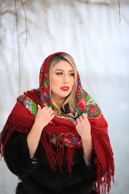 Een mooie vrouw met een Oekraïense hoofddoek loopt door het veld