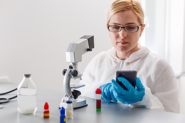 Een mooie vrouwelijke medische of wetenschappelijke onderzoeker die haar Microscoop in een laboratorium gebruikt.