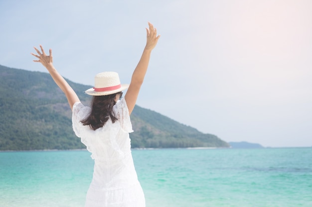 een mooie zorgeloze vrouw ontspannen aan het strand genieten van haar zon jurk vrijheid slijtage.