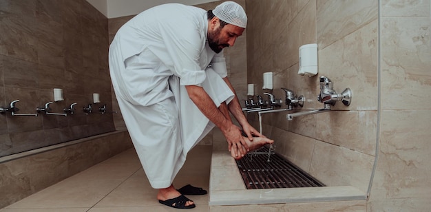 Een moslim die de wassing uitvoert. Rituele religieuze reiniging van moslims vóór het uitvoeren van het gebed. Het proces van het reinigen van het lichaam voor het gebed.