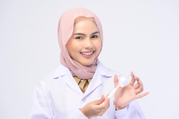 Een moslim vrouwelijke tandarts met Invisalign beugels op een witte achtergrond