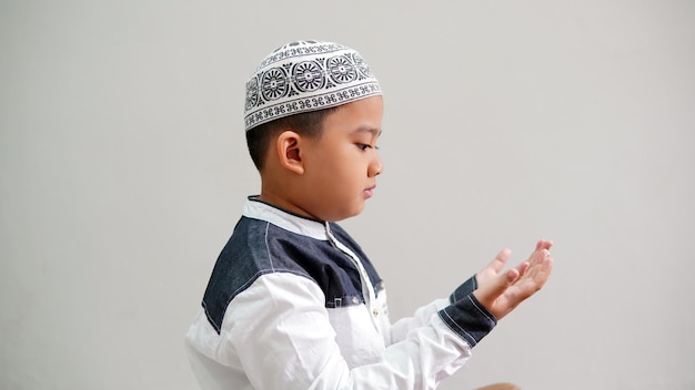 Foto een moslimjongen bidt na het gebed in de maand ramadan