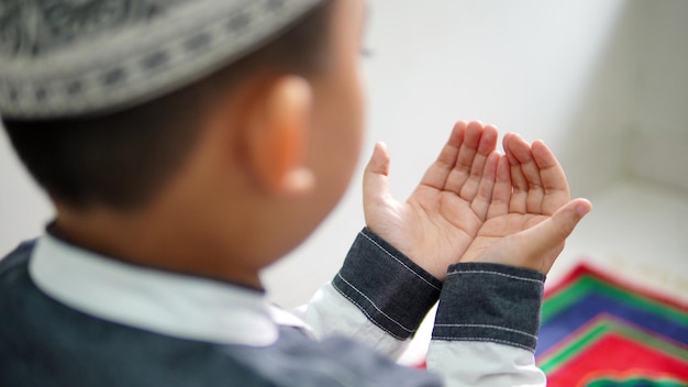 Foto een moslimjongen bidt na het gebed in de maand ramadan