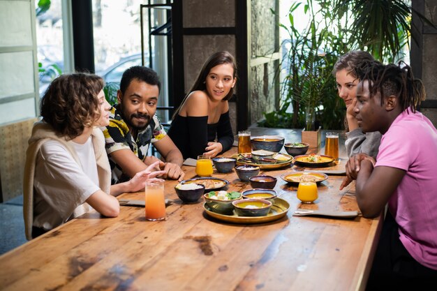 Een multi-etnische groep vrienden die zich vermaken in een café