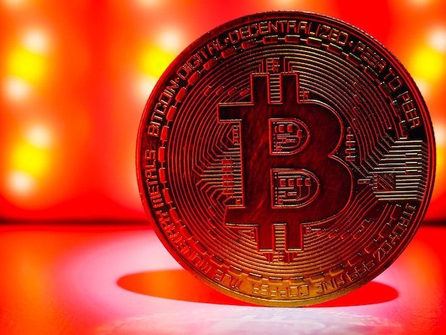 Een munt met bitcoin-symbool op rood licht. concept van een cryptocurrency-marktcrisis.