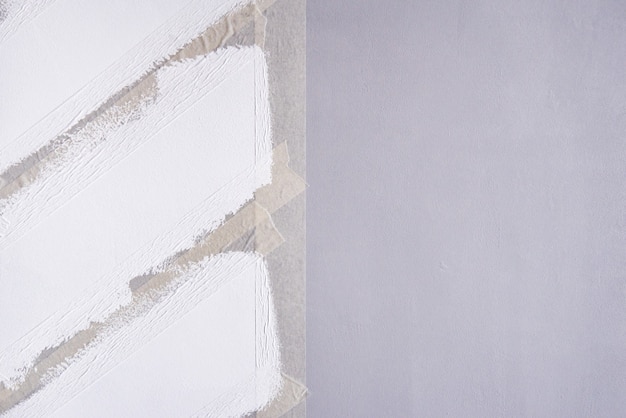 Foto een muur schilderen met plakband. witte zigzagstroken op grijze muur.
