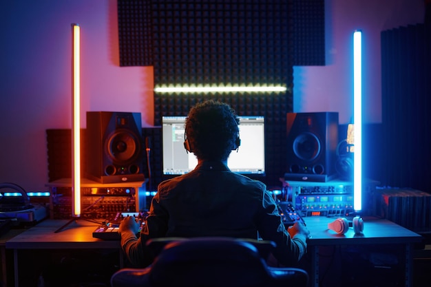 Een muziekproducent die in een opnamestudio werkt