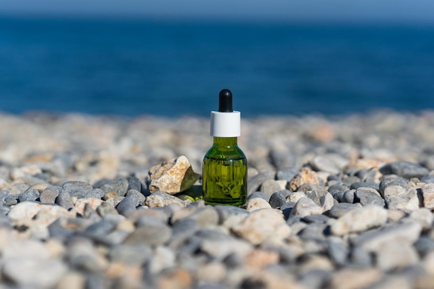Een natuurlijke etherische olie of serum die op de stenen aan de kust staat