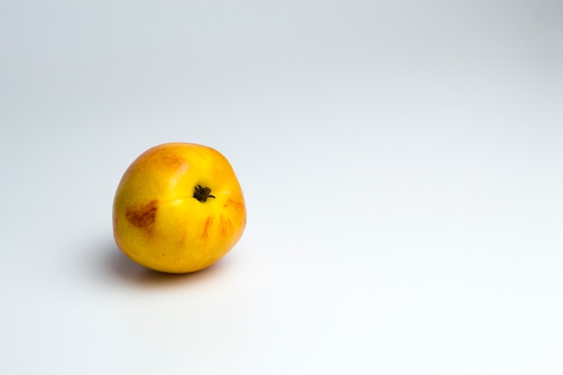 Eén nectarine ligt op een monochrome achtergrond, een dieetproduct, een product van oude mensen