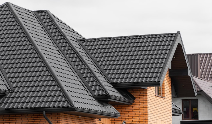 Foto een nieuw huis gemaakt van gele bakstenen en een prachtig zwart dak zwart gegolfd metalen profieldak geïnstalleerd op een modern huis