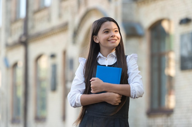 Een nieuw onderwijsperspectief. Gelukkig kind in uniform greepboek. Schoolbibliotheek. Basisonderwijs. Privé lesgeven. Priveles. 1 september Opstarten. Kennis dag. Opvoeden voor de toekomst.