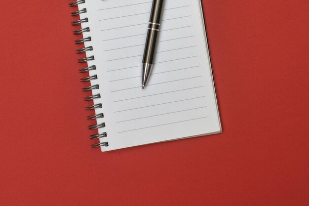 Een notitieboekje met een lege pagina en een pen erop
