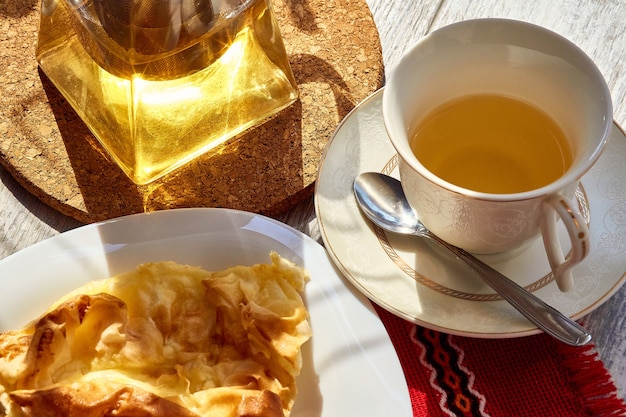 Foto een omelet in een bord op een houten tafel een theepot en een mok