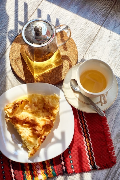 Foto een omelet in een bord op een houten tafel een theepot en een mok