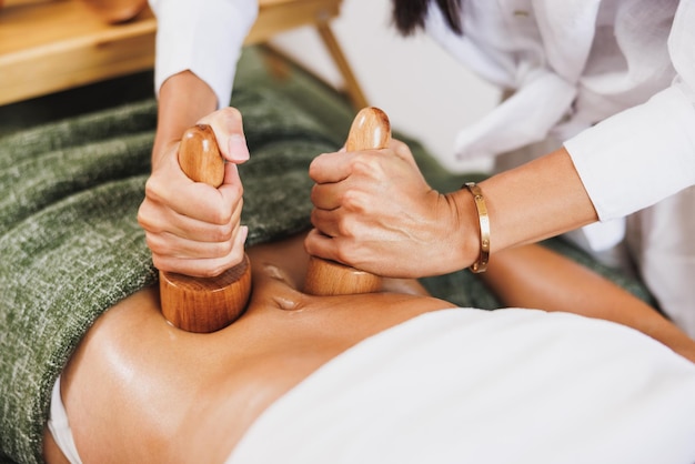 Een onherkenbare vrouw krijgt anti-cellulitis maderotherapie massage met houten beker in de schoonheidssalon.