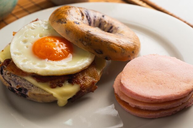 Foto een ontbijtbroodje met een gebakken ei en spek erop
