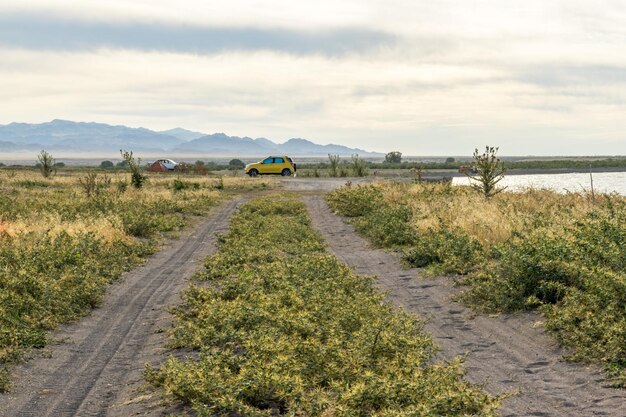 Een onverharde weg leidt naar een wild strand Kamperen in een tent Prachtige plek Wild toerisme