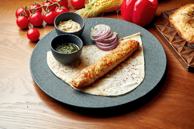 Een oosters gerecht van kip kebab van gehakt met lavash en groene saus. Halal eten