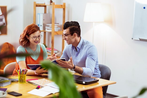 Een op een. Positieve aardige vrouw die lacht terwijl ze een individuele les heeft