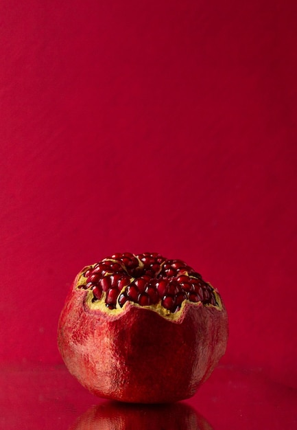 Een open granaatappel op een roze achtergrond. Ruimte voor tekst. bovenaanzicht