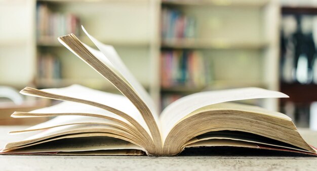 Een opengeslagen boek of leerboek in de bibliotheek met licht uit het raam op de leestafel