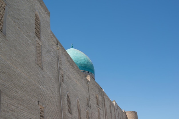 Een oud bakstenen gebouw met een toren Oude gebouwen van middeleeuws Azië Bukhara Oezbekistan